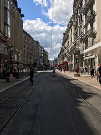 People walking on road along buildings