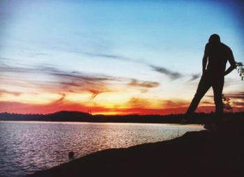 Silhouette of woman on sea during sunset