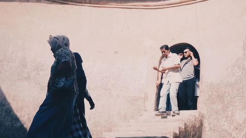 Young couple standing against wall