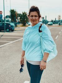 Portrait of woman standing on road