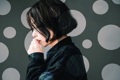 Side view of woman against wall