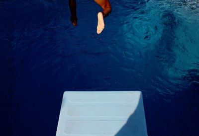 Low section of man standing on bed