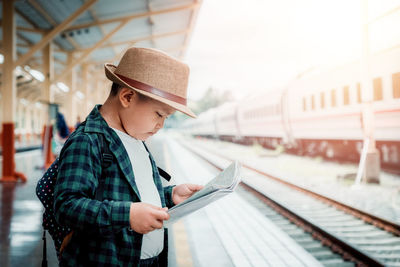 Man standing by train on railroad station platform
