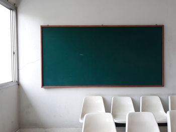 Empty chairs and blackboard in classroom