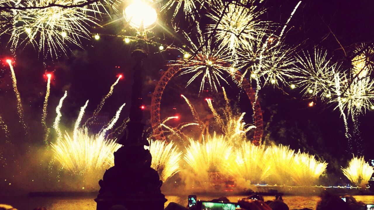 illuminated, palm tree, night, long exposure, water, firework display, motion, exploding, tree, glowing, sparks, low angle view, celebration, blurred motion, sky, outdoors, arts culture and entertainment, firework - man made object, nature, no people