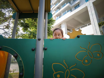 Little girl peeking from at the playground.