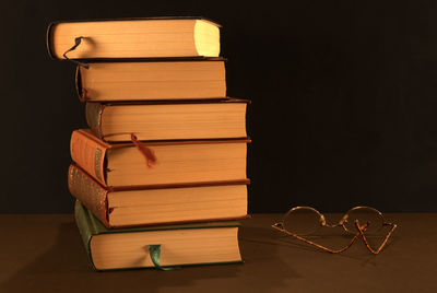 Stack of books on table against black background