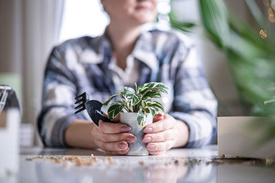 Midsection of woman sitting on table