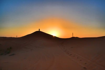 Scenic view of desert against sky during sunset