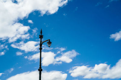 Low angle view of weather vane against blue sky