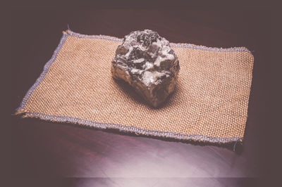 Close-up of quartz and mica schist rock on jute fabric over table