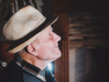 Close-up of senior man wearing hat at home