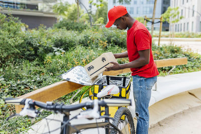 Delivery man examining package at bench