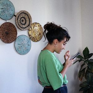 Side view of woman standing against wall at home