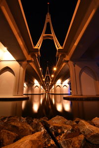 Low angle view of illuminated bridge at night