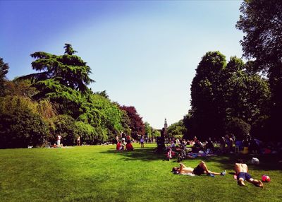 People playing in park against sky