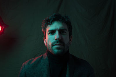 Portrait of young man against black background