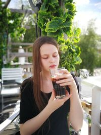 Beautiful young woman drinking drink