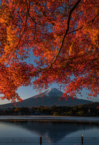 Scenic view of lake against snowcapped mountain during autumn at sunset