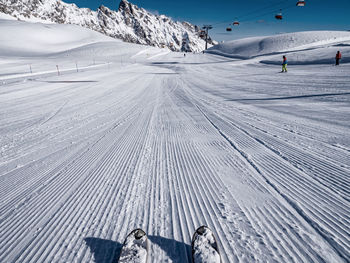 View of people skiing on snow covered mountain