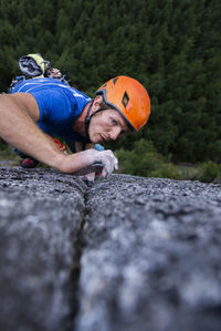 Close up of climber looking very focused on next move while climbing