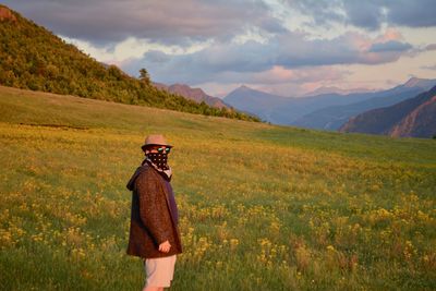 Man standing on field against mountains