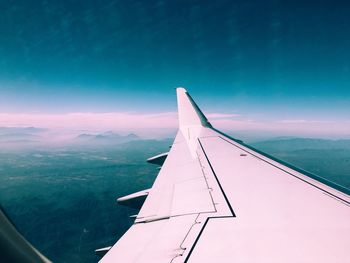 Low angle view of airplane wing against sky