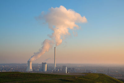 Smoke emitting from chimney against sky