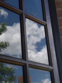 Low angle view of glass window against sky