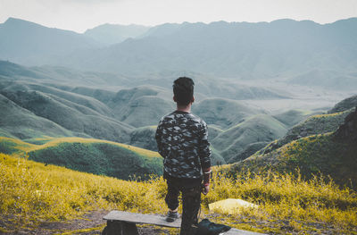 Rear view of man standing on mountain