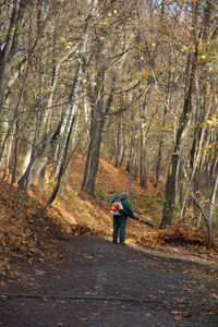 Man standing amidst trees in forest