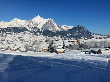 Scenic view of snowcapped mountains against clear blue sky