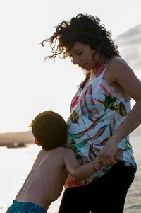 Mother and son standing on beach