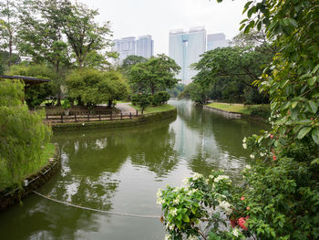 Scenic view of lake against sky in city