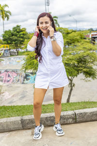 Portrait of smiling young woman standing on bridge