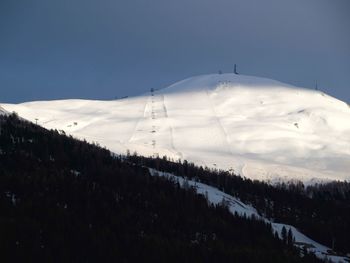 Scenic view of snow covered on mountains against clear sky