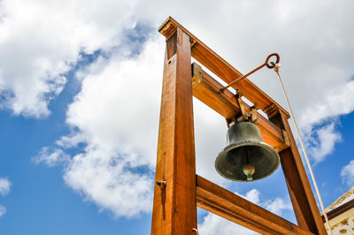 Low angle view of bell tower against cloudy sky