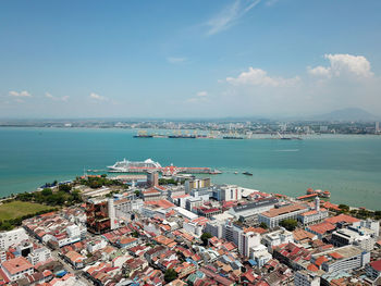 High angle view of townscape by sea against sky