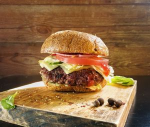 Close-up of hamburger on wooden cutting board