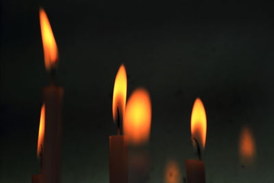 Close-up of lit candle in dark room