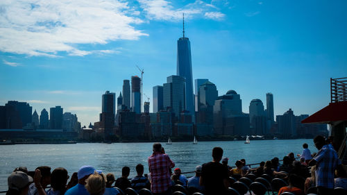 People on modern buildings in city against sky