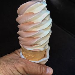 Close-up of hand holding ice cream against black background