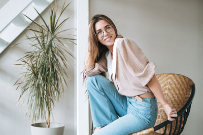 Portrait of young woman using mobile phone at home