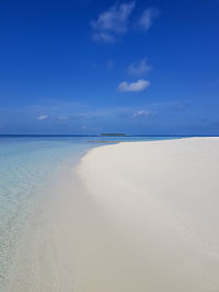 Scenic view of beach against blue sky