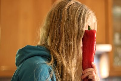 Rear view of woman holding red bell pepper