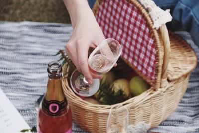 Low section of woman holding drink in basket