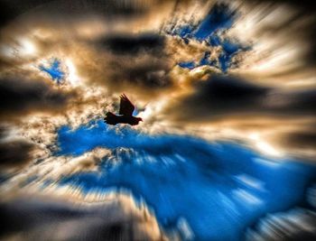 Low angle view of airplane flying against cloudy sky