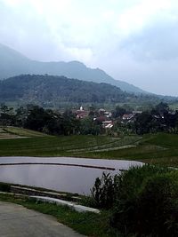 Scenic view of lake against cloudy sky