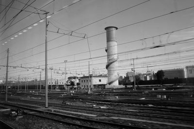 Electricity pylon in city against sky