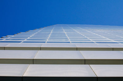 Low angle view of office building against blue sky